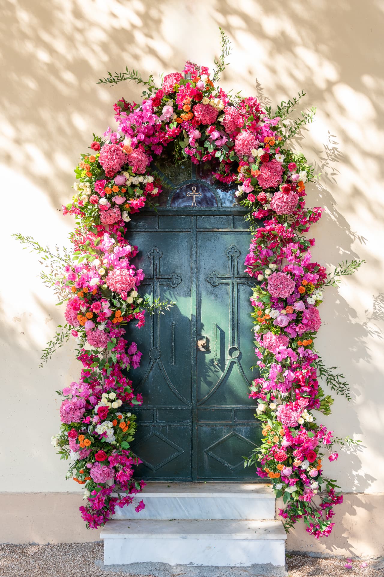 Vibrant pink floral arrangement framing a dark green doorway